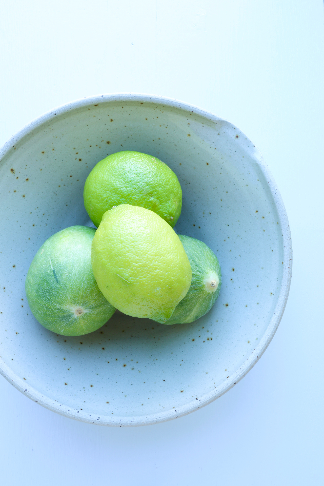 Speckled ceramic bowl with a cream linen napkin on a warm terracotta surface