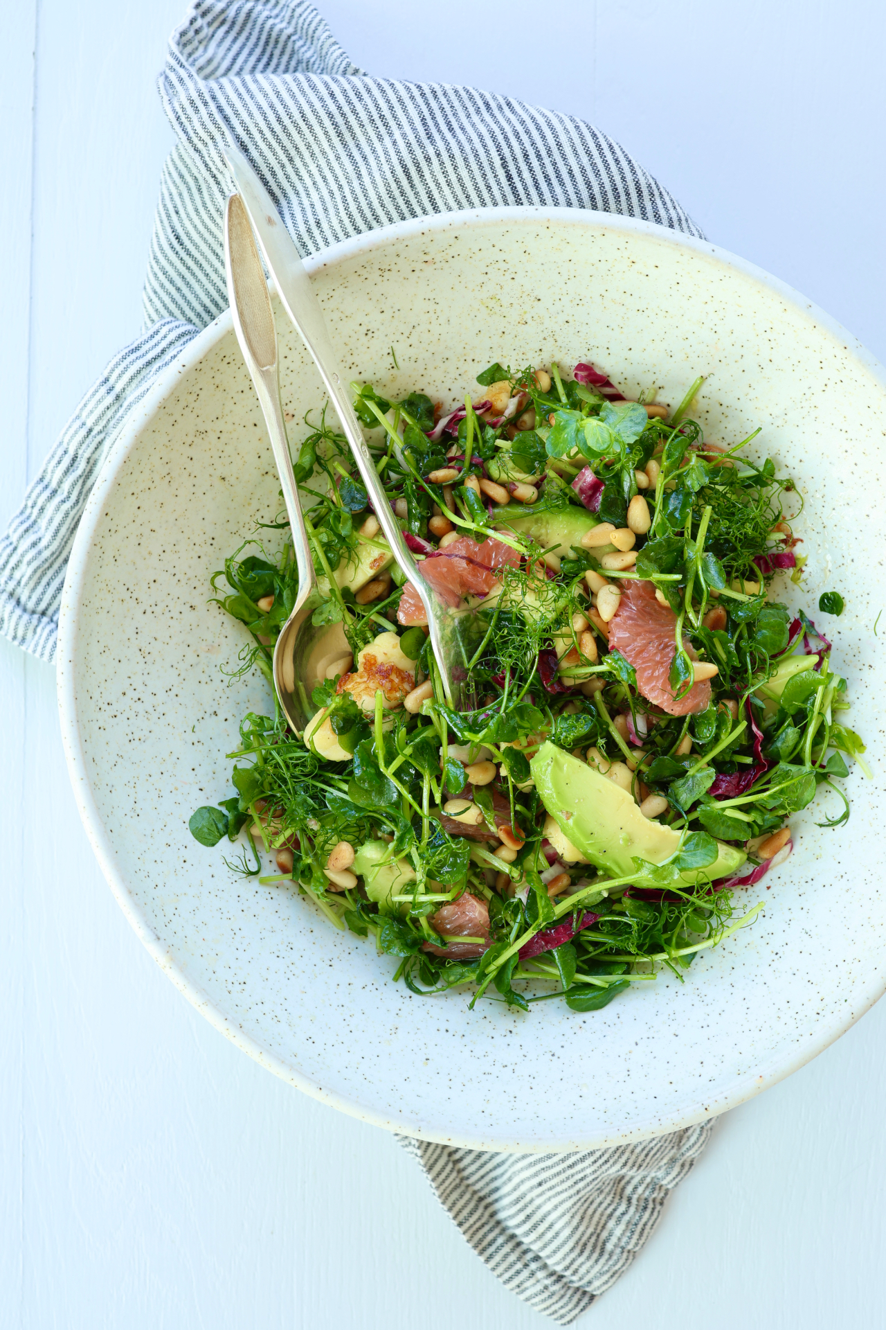 Pea shoot salad with grapefruit, avocado and grilled cheese on a plate