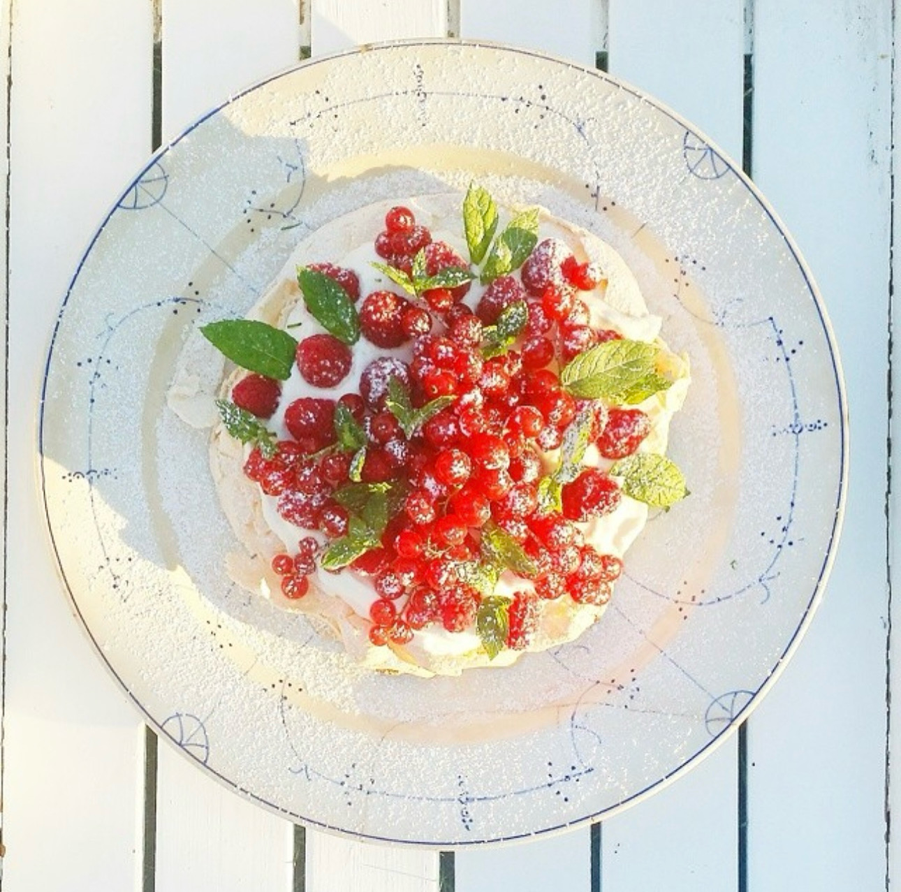 Summer berry pavlova with whipped cream, raspberries and redcurrants