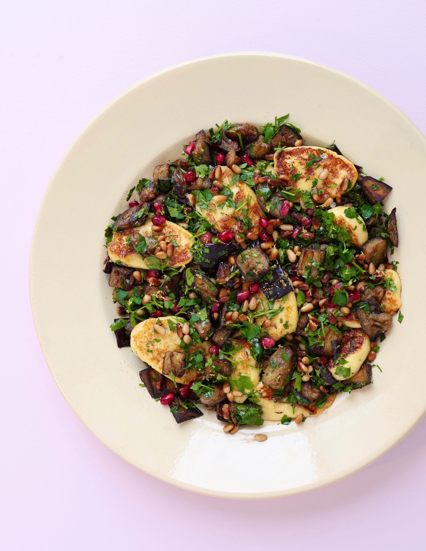 Crispy halloumi with roasted aubergine, pomegranate seeds and pine nuts on a platter